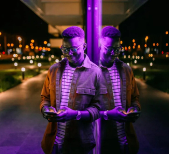 Young man using his phone leaning against a building 350.jpeg.jpg